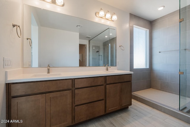 bathroom with vanity, a shower with shower door, and wood-type flooring