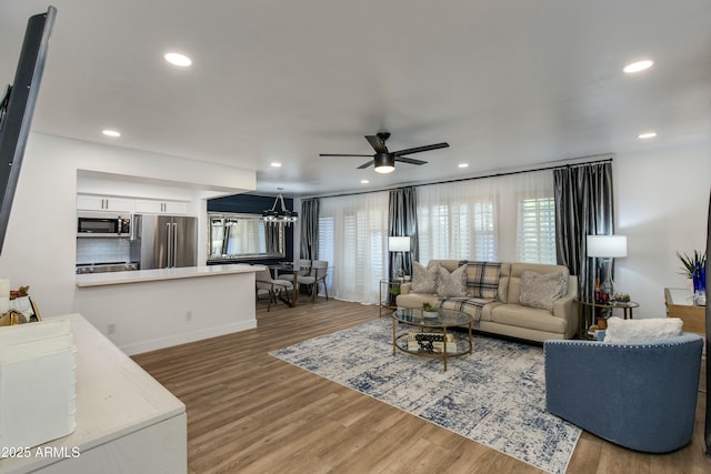 living area with recessed lighting, wood finished floors, and ceiling fan