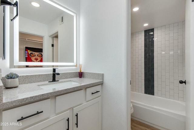 bathroom featuring visible vents, toilet, shower / washtub combination, recessed lighting, and vanity