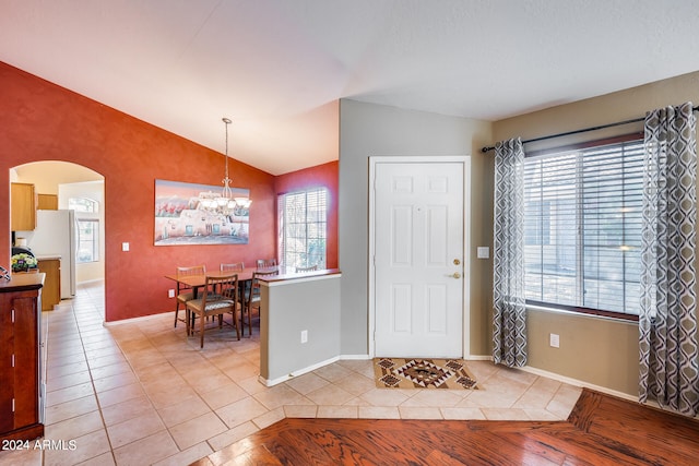 tiled foyer featuring vaulted ceiling