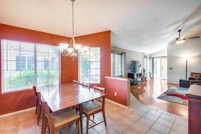 tiled dining room featuring vaulted ceiling, plenty of natural light, and ceiling fan with notable chandelier