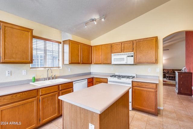 kitchen featuring a kitchen island, white appliances, lofted ceiling, rail lighting, and sink