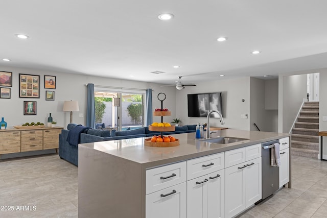 kitchen with sink, dishwasher, ceiling fan, a kitchen island with sink, and white cabinets