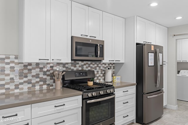 kitchen featuring stainless steel appliances, white cabinets, light tile patterned flooring, washer / clothes dryer, and decorative backsplash