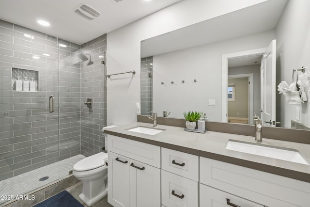 bathroom featuring vanity, a shower with door, and toilet