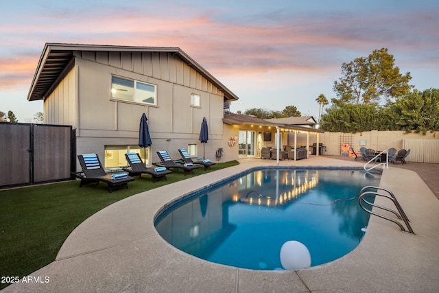 pool at dusk featuring outdoor lounge area and a patio area