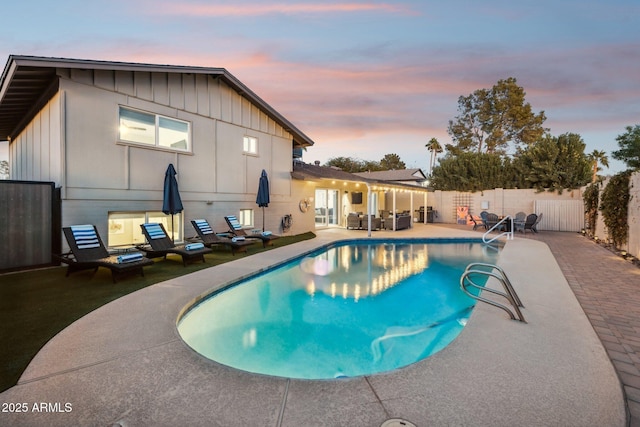 pool at dusk featuring a patio area