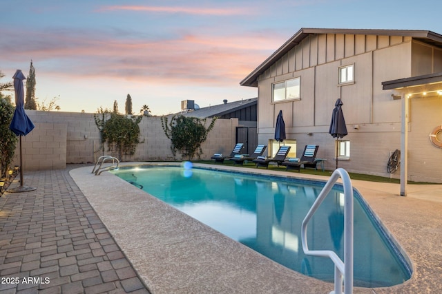 pool at dusk featuring a patio area