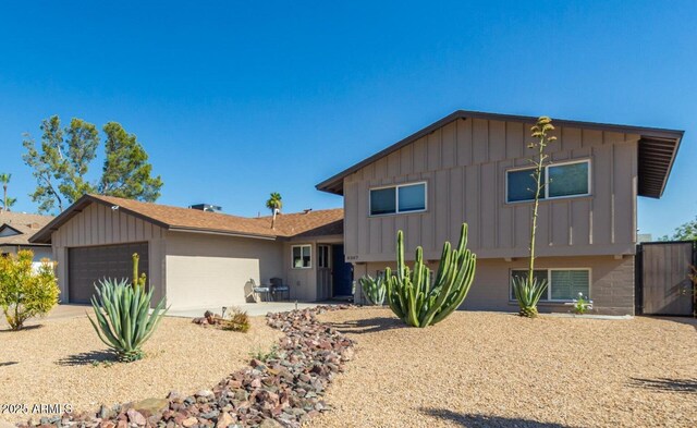 8307 E Montebello Ave, Scottsdale, AZ 85250 - split level home with driveway, an attached garage, and board and batten siding