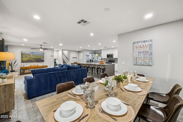 tiled dining room with sink and ceiling fan