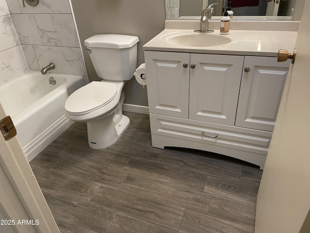 full bathroom with hardwood / wood-style flooring, vanity, toilet, and tiled shower / bath combo