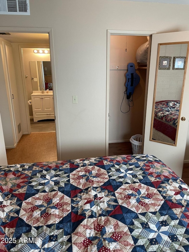 bedroom featuring ensuite bath, a walk in closet, and a closet