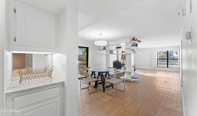 dining area featuring a textured ceiling and light wood finished floors