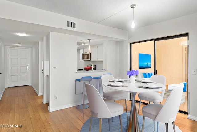 dining area featuring baseboards, visible vents, and light wood-style floors