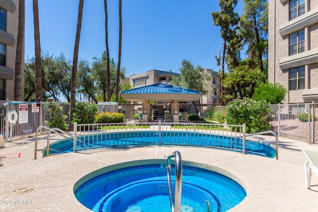 pool with a community hot tub, fence, and a patio