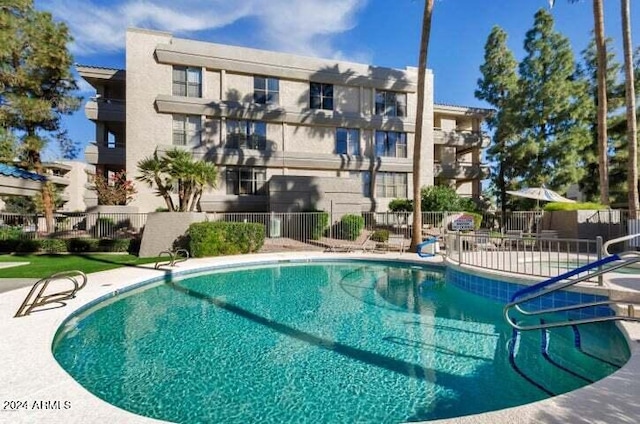 community pool featuring a patio area and fence