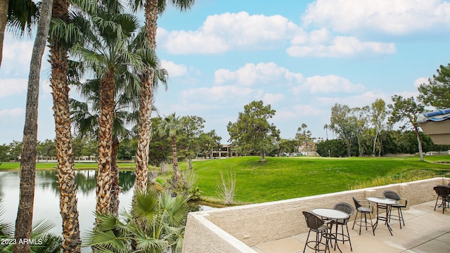 view of home's community featuring a patio area, a water view, and a lawn