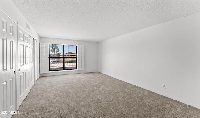 unfurnished bedroom featuring carpet, a closet, visible vents, and a textured ceiling