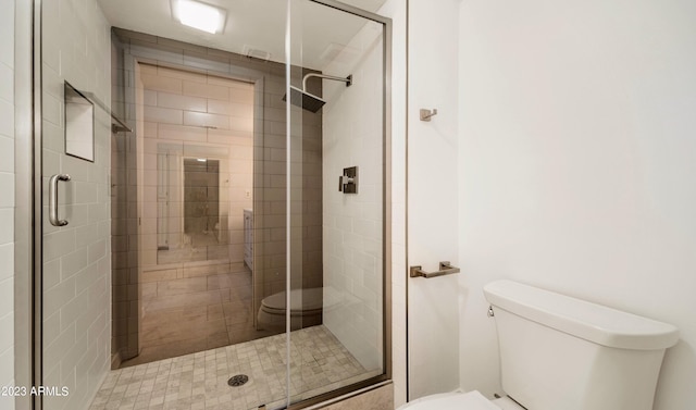 full bath featuring a shower stall and toilet