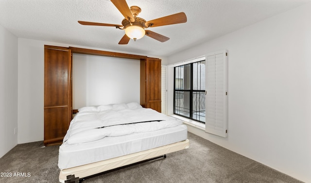 bedroom with carpet floors, ceiling fan, and a textured ceiling