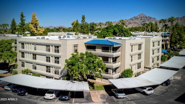 view of property featuring a mountain view and covered and uncovered parking