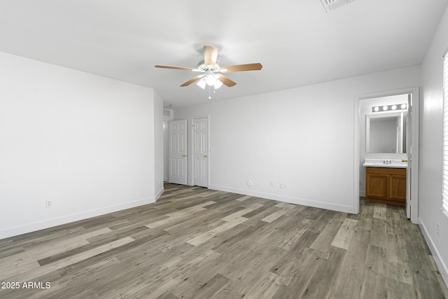1750 E Desert Rose Trl, San Tan Valley, AZ 85143 - unfurnished bedroom with visible vents, light wood finished floors, baseboards, a sink, and ensuite bath