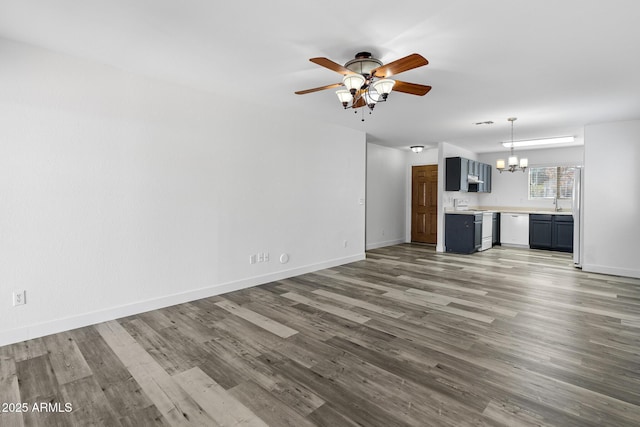 1750 E Desert Rose Trl, San Tan Valley, AZ 85143 - unfurnished living room featuring a sink, ceiling fan with notable chandelier, baseboards, and wood finished floors