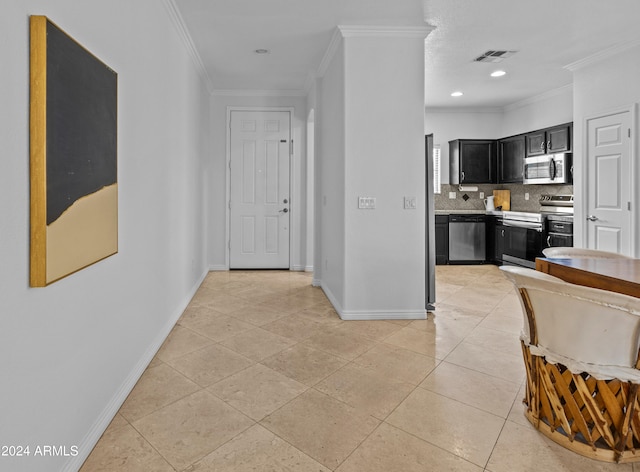 kitchen with decorative backsplash, crown molding, light tile patterned flooring, and appliances with stainless steel finishes