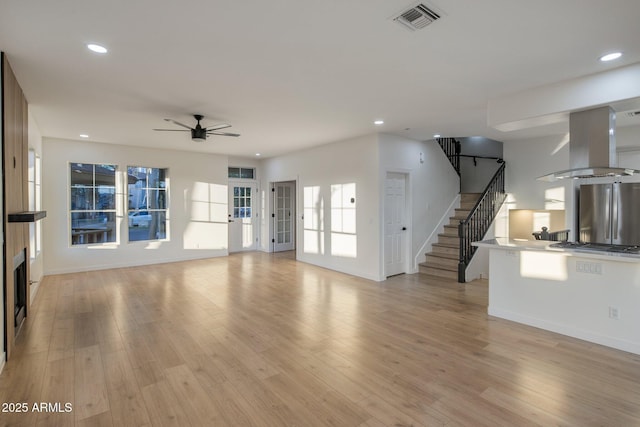 942 S Ash Ave Unit 104, Tempe, AZ 85281 - unfurnished living room featuring a ceiling fan, stairway, light wood-style floors, recessed lighting, and baseboards
