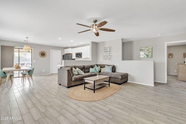 living room with light hardwood / wood-style flooring and ceiling fan