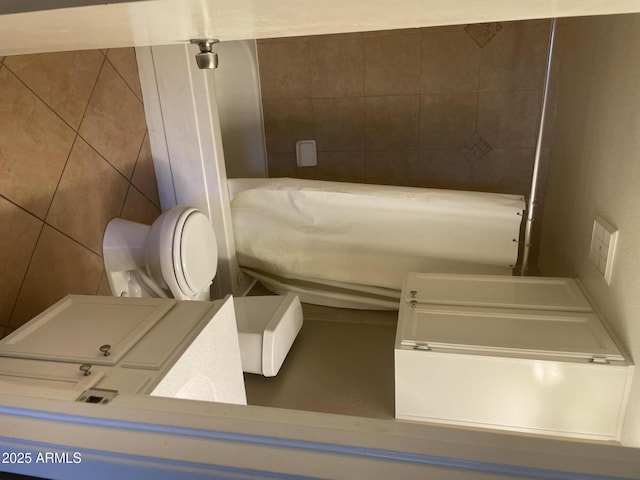 full bath featuring tile walls and toilet