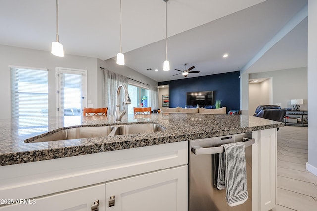 kitchen featuring dishwasher, open floor plan, a sink, and white cabinets