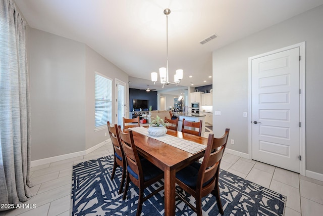 dining area with light tile patterned floors, baseboards, visible vents, and a chandelier