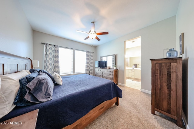 bedroom with light carpet, ensuite bath, a ceiling fan, and baseboards