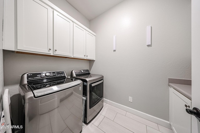 laundry room with cabinet space, baseboards, separate washer and dryer, and light tile patterned flooring