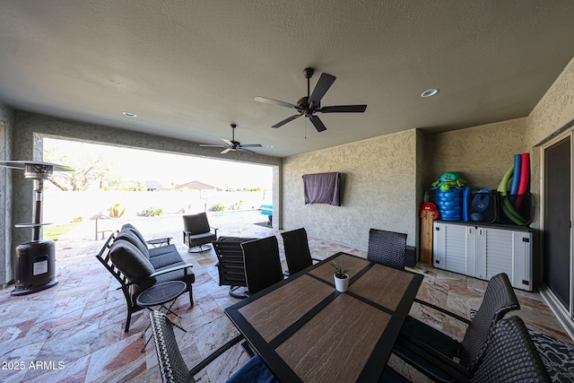 view of patio with outdoor dining area, fence, and a ceiling fan