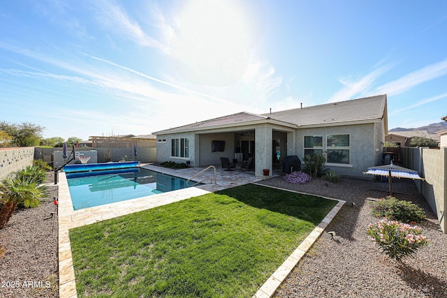 back of property featuring a fenced backyard, a fenced in pool, a lawn, and a patio