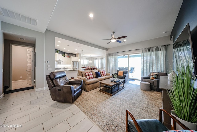 living room with recessed lighting, visible vents, ceiling fan, and baseboards