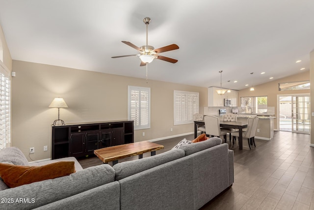 living room featuring lofted ceiling, a healthy amount of sunlight, dark wood-type flooring, and ceiling fan