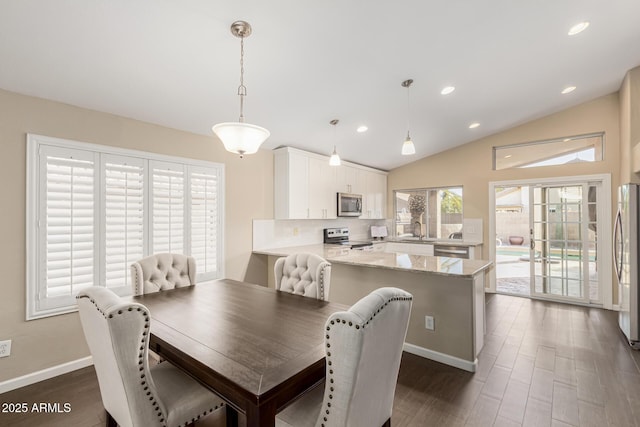 dining room featuring sink, dark wood-type flooring, and vaulted ceiling