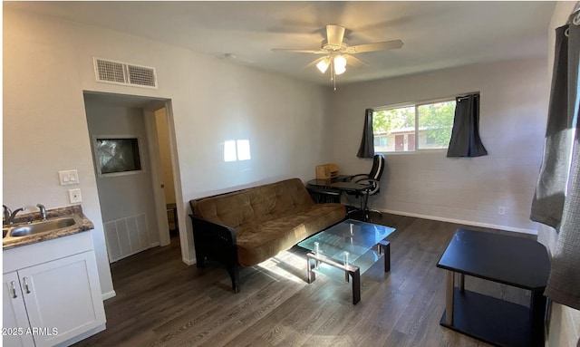 living area featuring dark wood-style flooring, visible vents, and ceiling fan