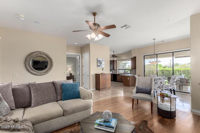 16540 E El Lago Blvd Unit 2, Fountain Hills, AZ 85268 - living room featuring a ceiling fan, baseboards, and light wood-type flooring