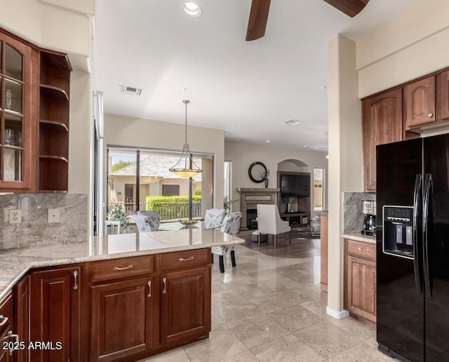 16540 E El Lago Blvd Unit 2, Fountain Hills, AZ 85268 - kitchen featuring black fridge, ceiling fan, decorative backsplash, a fireplace, and a peninsula