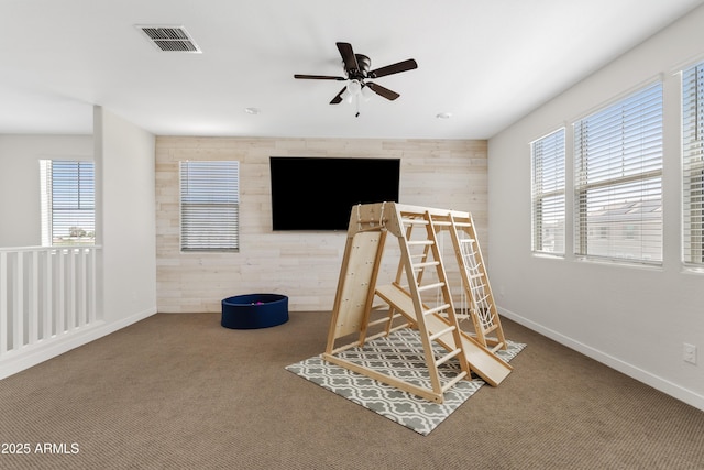 1800 S Jesse Pl, Chandler, AZ 85286 - game room with healthy amount of natural light, wood walls, carpet floors, and a ceiling fan