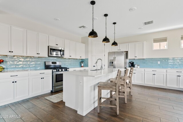 1800 S Jesse Pl, Chandler, AZ 85286 - kitchen with appliances with stainless steel finishes, backsplash, wood finished floors, and light countertops