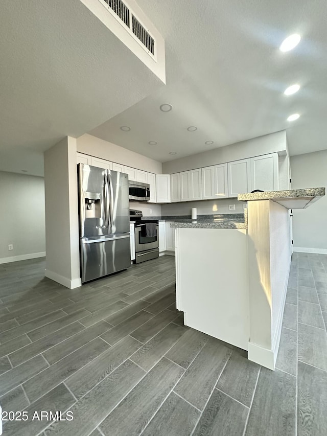 4902 S Fair Ln, Tempe, AZ 85282 - kitchen with appliances with stainless steel finishes, baseboards, wood finish floors, recessed lighting, and a textured ceiling