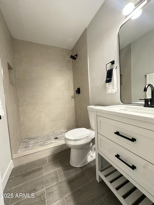4902 S Fair Ln, Tempe, AZ 85282 - full bathroom featuring a tile shower, toilet, vanity, and wood finish floors