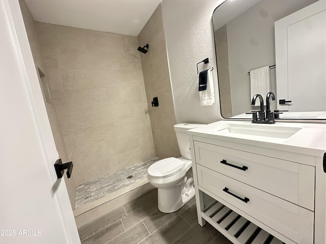 4902 S Fair Ln, Tempe, AZ 85282 - bathroom with toilet, vanity, tiled shower, and wood finished floors