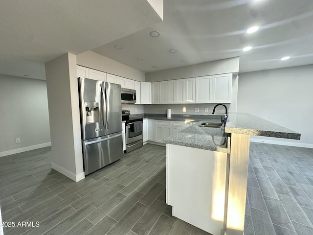 4902 S Fair Ln, Tempe, AZ 85282 - kitchen featuring appliances with stainless steel finishes, a sink, baseboards, a peninsula, and wood tiled floors
