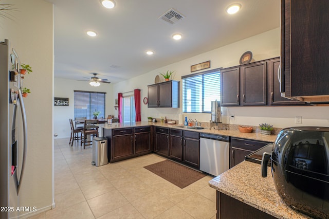 kitchen featuring kitchen peninsula, appliances with stainless steel finishes, ceiling fan, and dark brown cabinetry